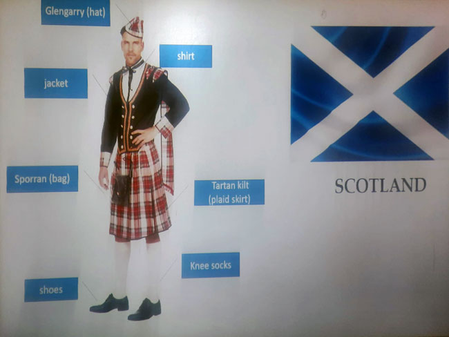 Plansza - Szkot w stroju narodowym, flaga Szkocji, czarne i białe napisy.