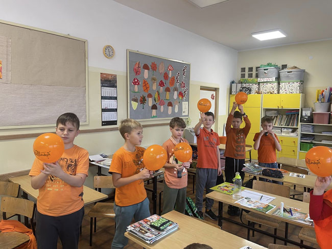 Sala lekcyjna - chłopcy z pomarańczowymi balonami.