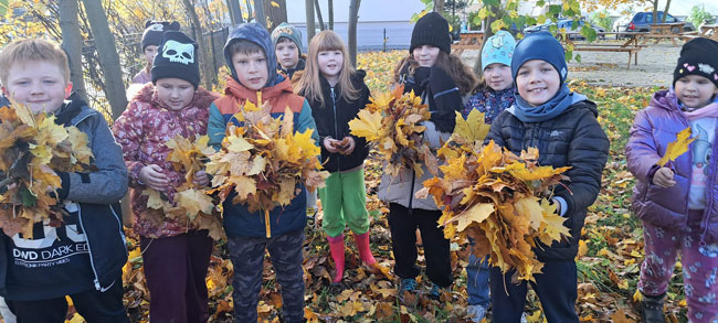 Dzieci trzymające kolorowe liście.