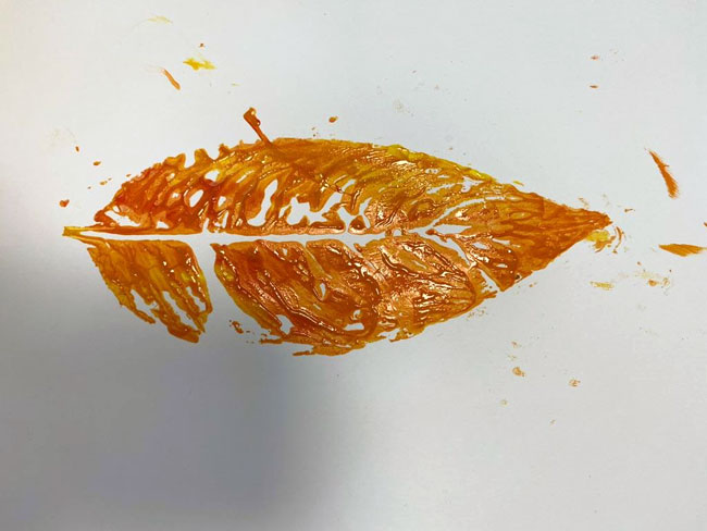 Namalowany pomarańczowy liść.