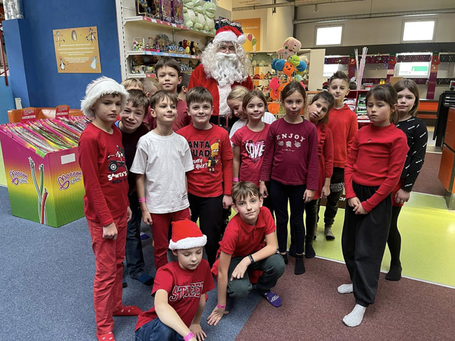 Dzieci w czerwonych ubraniach z Mikołajem.
