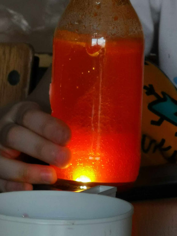 Butelka z pomarańczową cieczą.