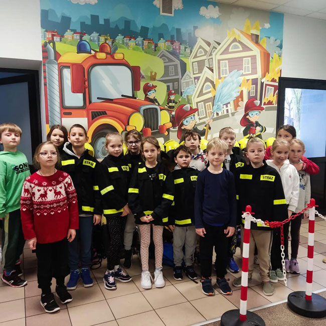 Grupa dzieci w strojach strażaka.